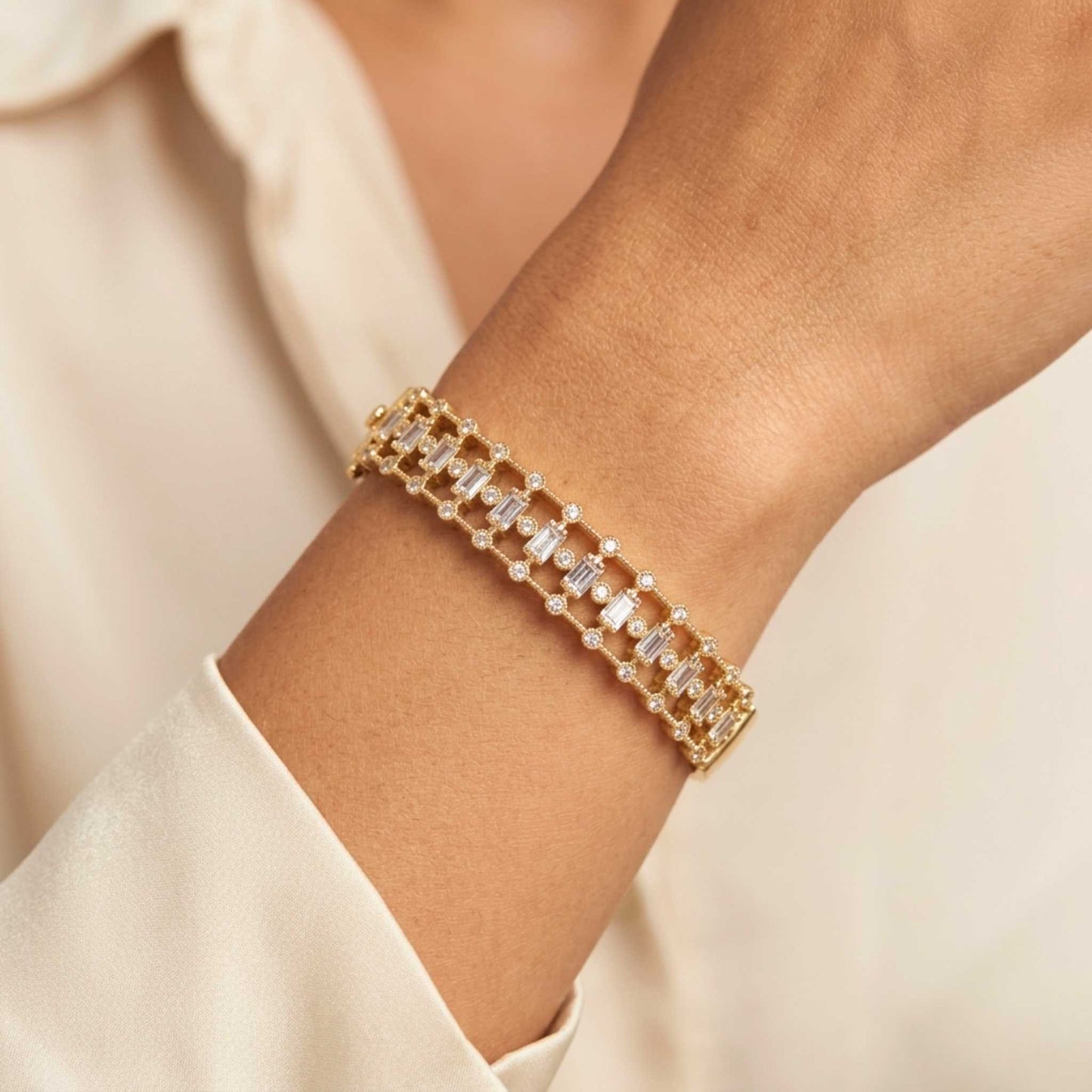Women's wrist with a Gold-toned hinged bangle bracelet featuring an intricate front band set with vertical baguette-cut and round brilliant-cut cubic zirconia gemstones.  Digitally rendered model for scale
