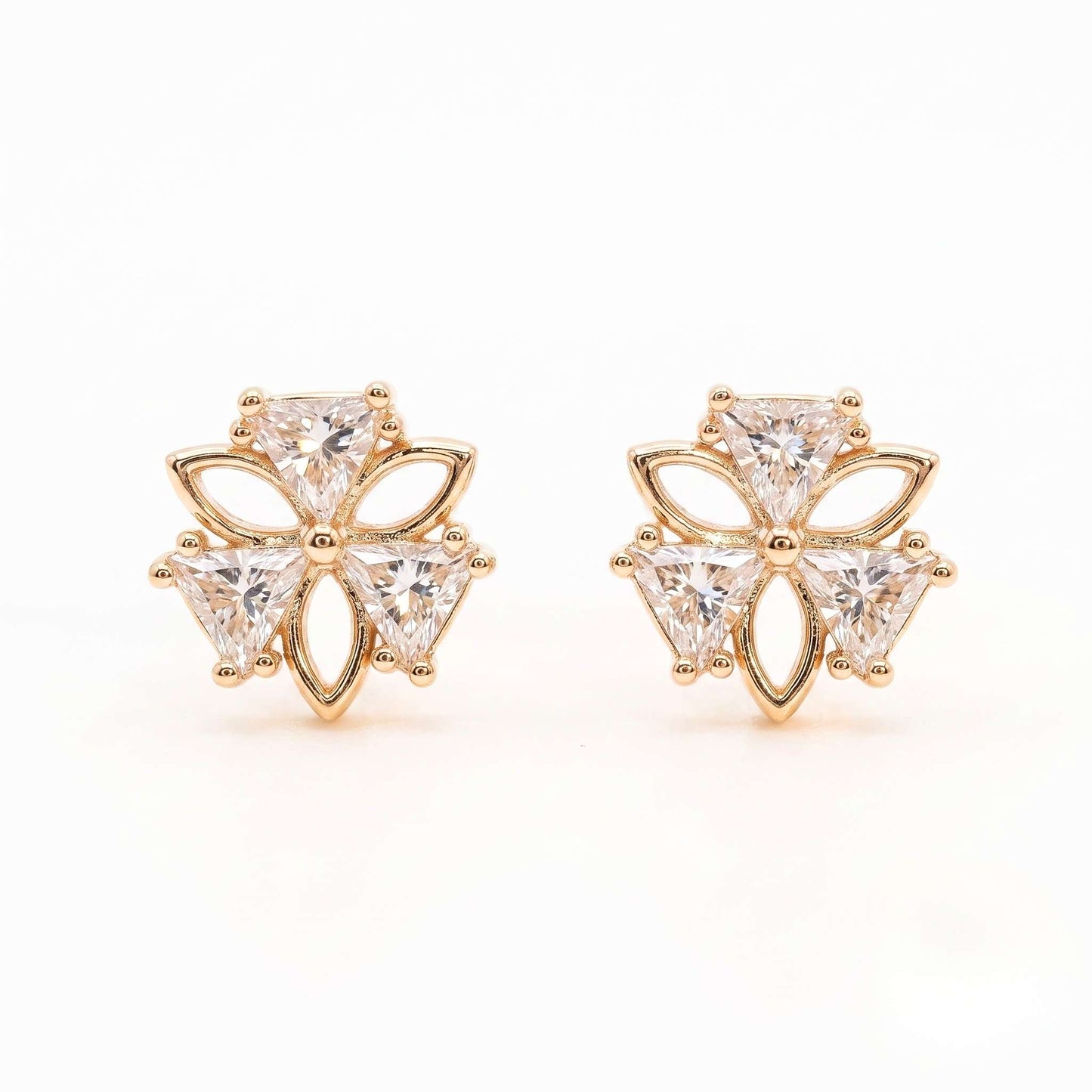 A detailed close-up picture of a pair of gold plated stud earrings in a sweet clover design featuring cubic zirconia from the jewellery 4 Elegance on a white background.