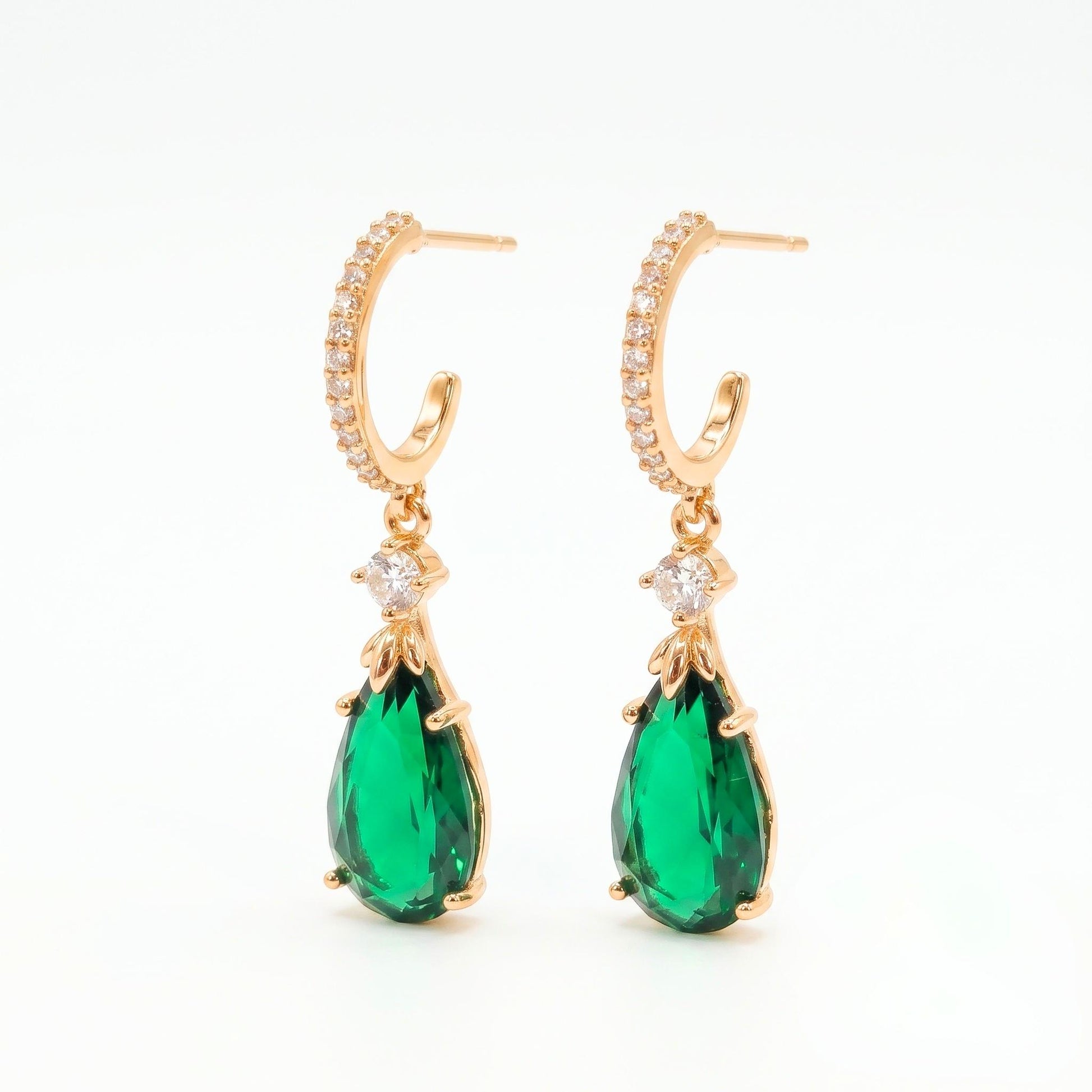 Warm gold-plated semi-hoop stud earrings embellished with clear pavé cubic zirconia and a hanging emerald green teardrop pendant from Jewellery 4 Elegance collection