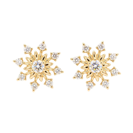 A pair of gold snowflake stud earrings with clear round-cut centre stones and smaller surrounding stones from the Jewellery 4 Elegance collection, shown on a plain white background.