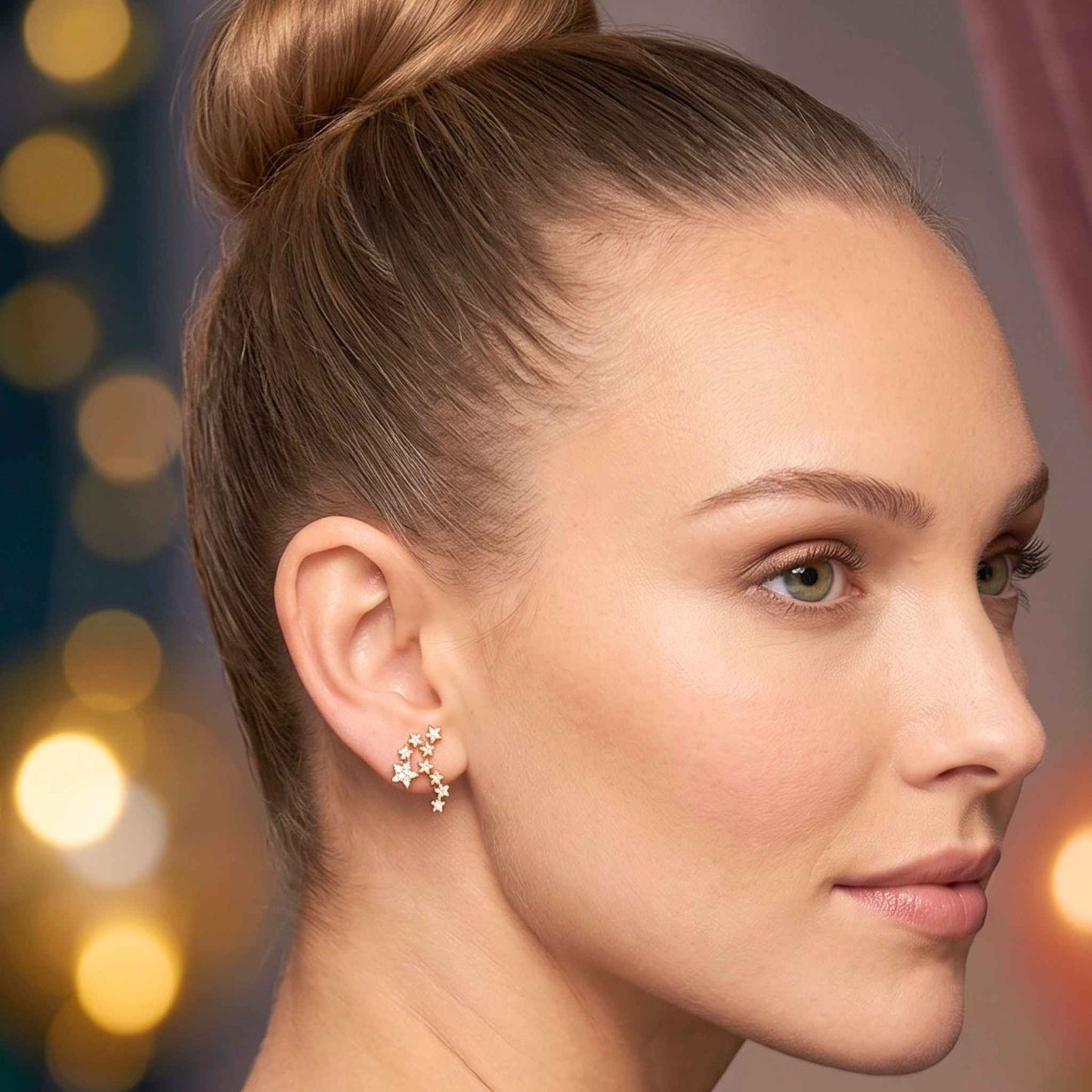 A close-up portrait of a woman with her hair in a high bun, wearing a pair of quality gold stud ear climber earrings in a fun constellation star cluster design embedded with glittering cubic zirconia from the Jewellery 4 Collection against a softly blurred background.  Digitally rendered model for scale