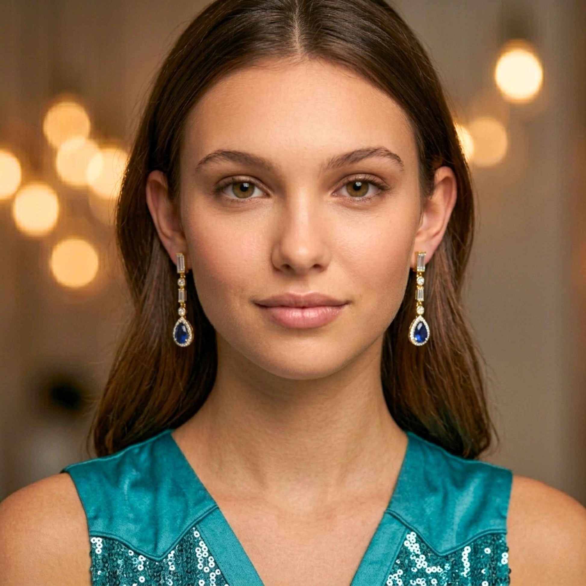 Women in a turquoise dress wearing sapphire blue gold drop earrings.   Digitally rendered model for scale