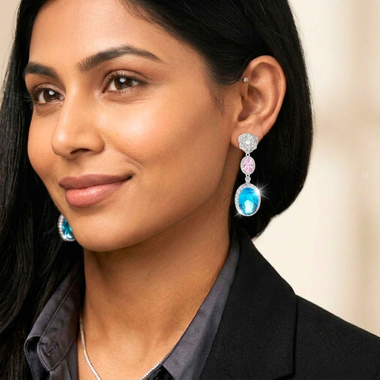 Woman wearing colorful earrings with a neutral background