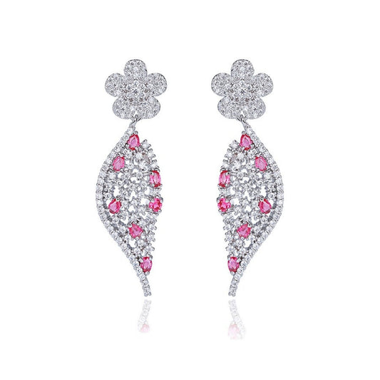 Elegant Jewellery 4 Elegance white gold plated drop earrings featuring a pave flower post and a curved leaf silhouette embedded with clear and vibrant red cubic zirconia gemstones set against a white background.