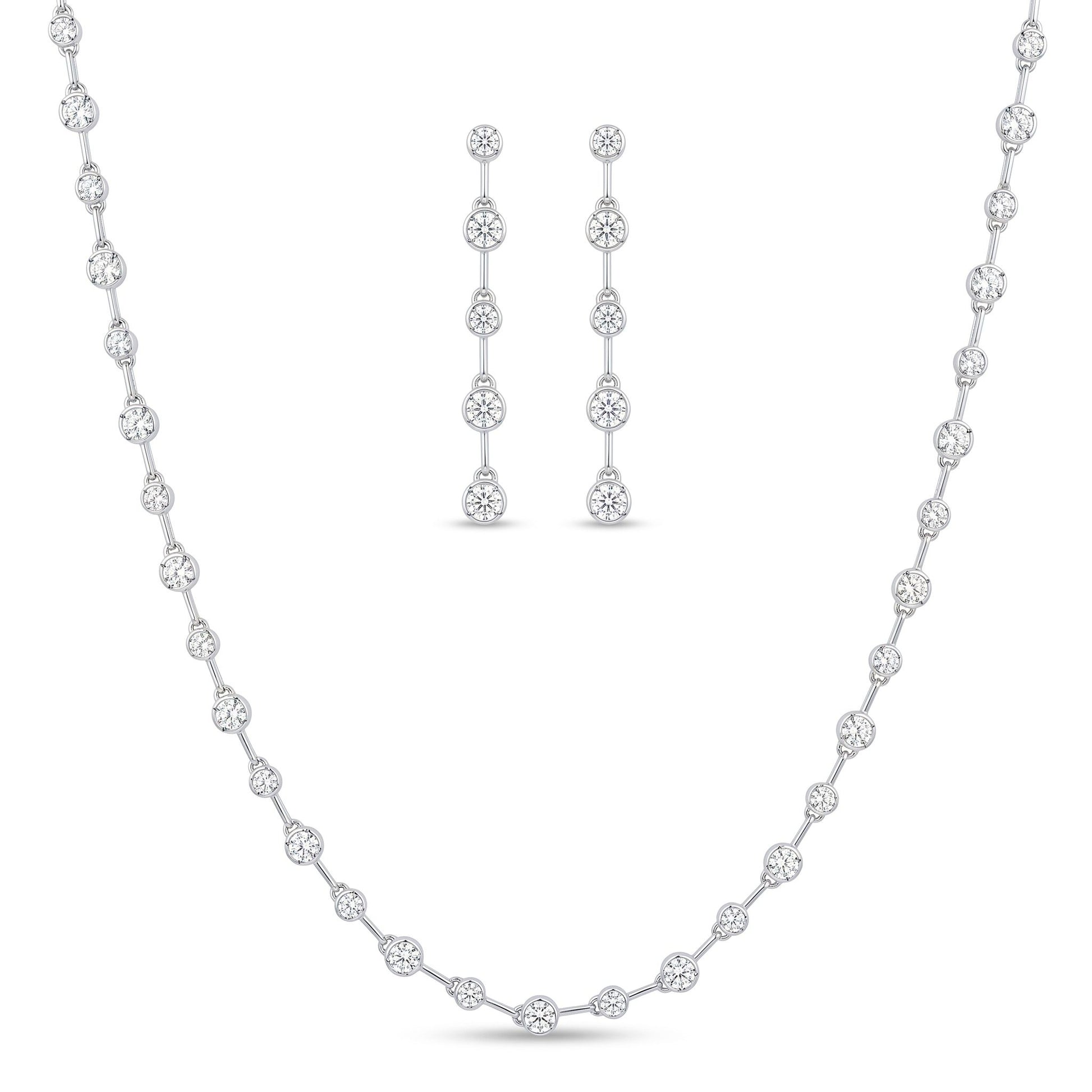 A white gold jewellery set featuring a delicate necklace and matching drop earrings, both adorned with clear round-cut stones, displayed on a clean white background.  From the jewellery f4 Elegance collection.