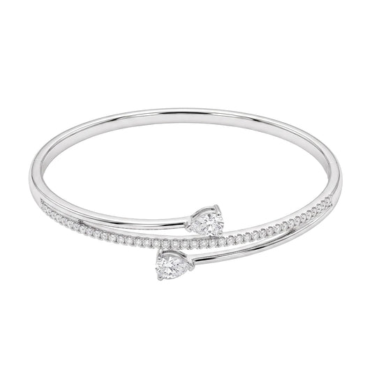 White gold crossover bangle bracelet with two pear-cut cubic zirconia, a row of round cubic zirconia and a concealed clasp from the Jewellery 4 Elegance collection.